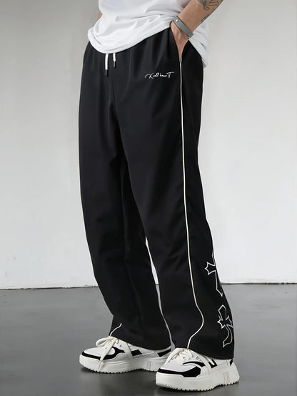 Pantalones Street Shadow Line de THE LJM, pantalones deportivos negros con línea de sombra en los lados, vistas desde el frente.