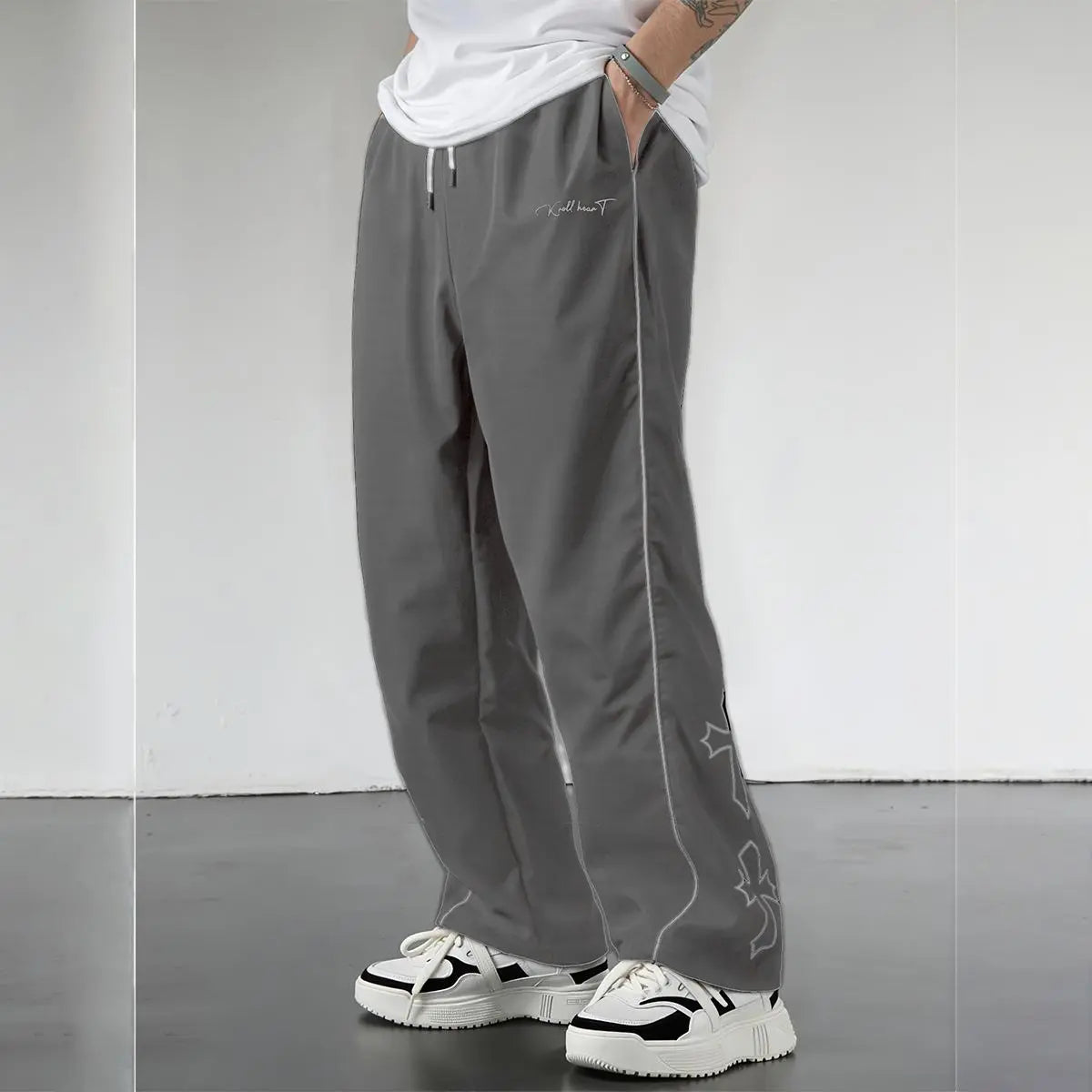 Pantalones Street Shadow Line de THE LJM en color gris oscuro, con corte ajustado y detalles de costuras visibles.