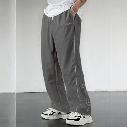 Pantalones Street Shadow Line de THE LJM en color gris oscuro, con corte ajustado y detalles de costuras visibles.